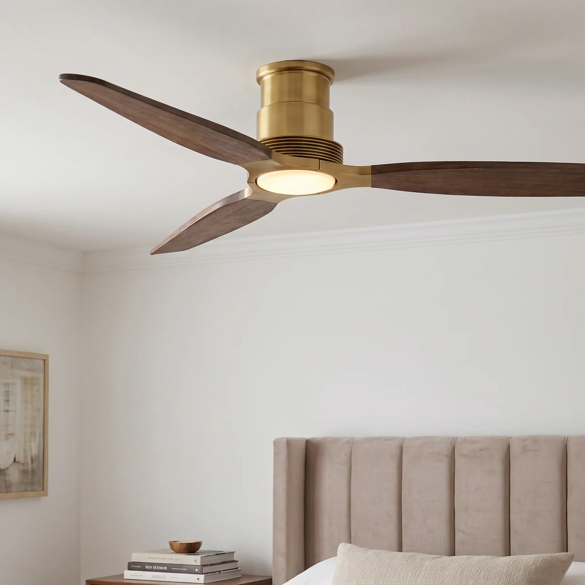 Modern ceiling fan with brass finish, dark wood blades, and integrated light.
