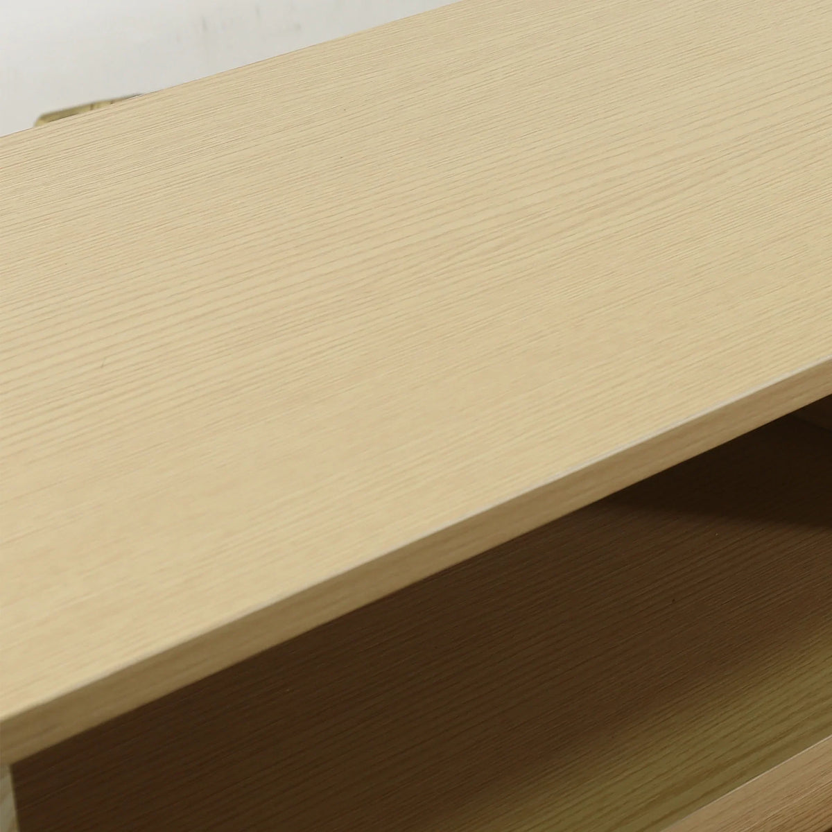 Close-up of a light-colored wood grain furniture shelf surface