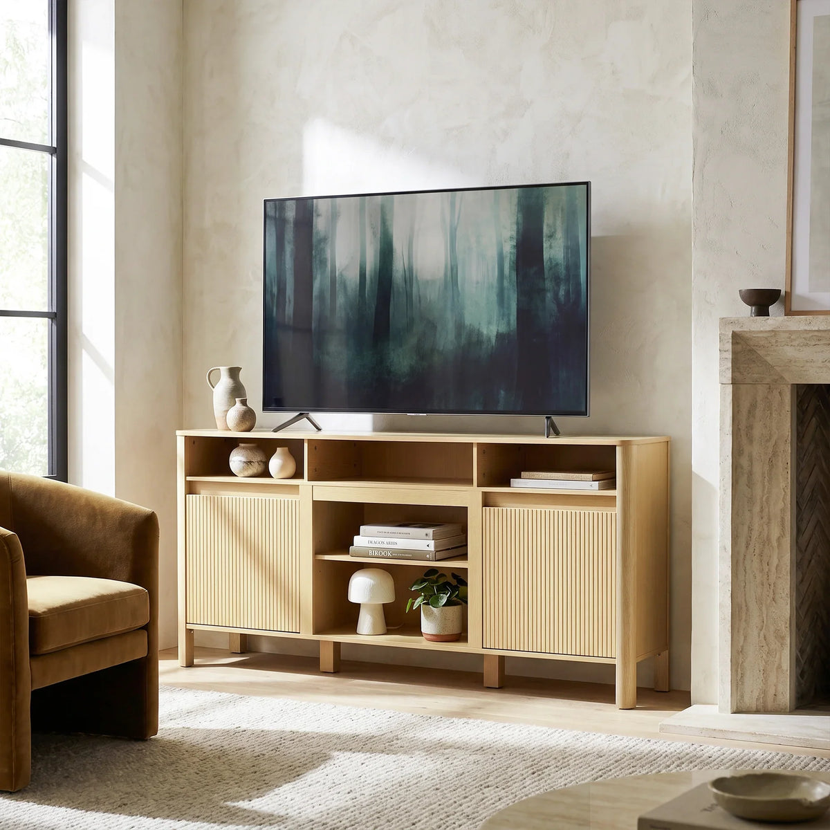 Modern light wood TV stand with storage cabinets and open shelving in a minimalist living room.
