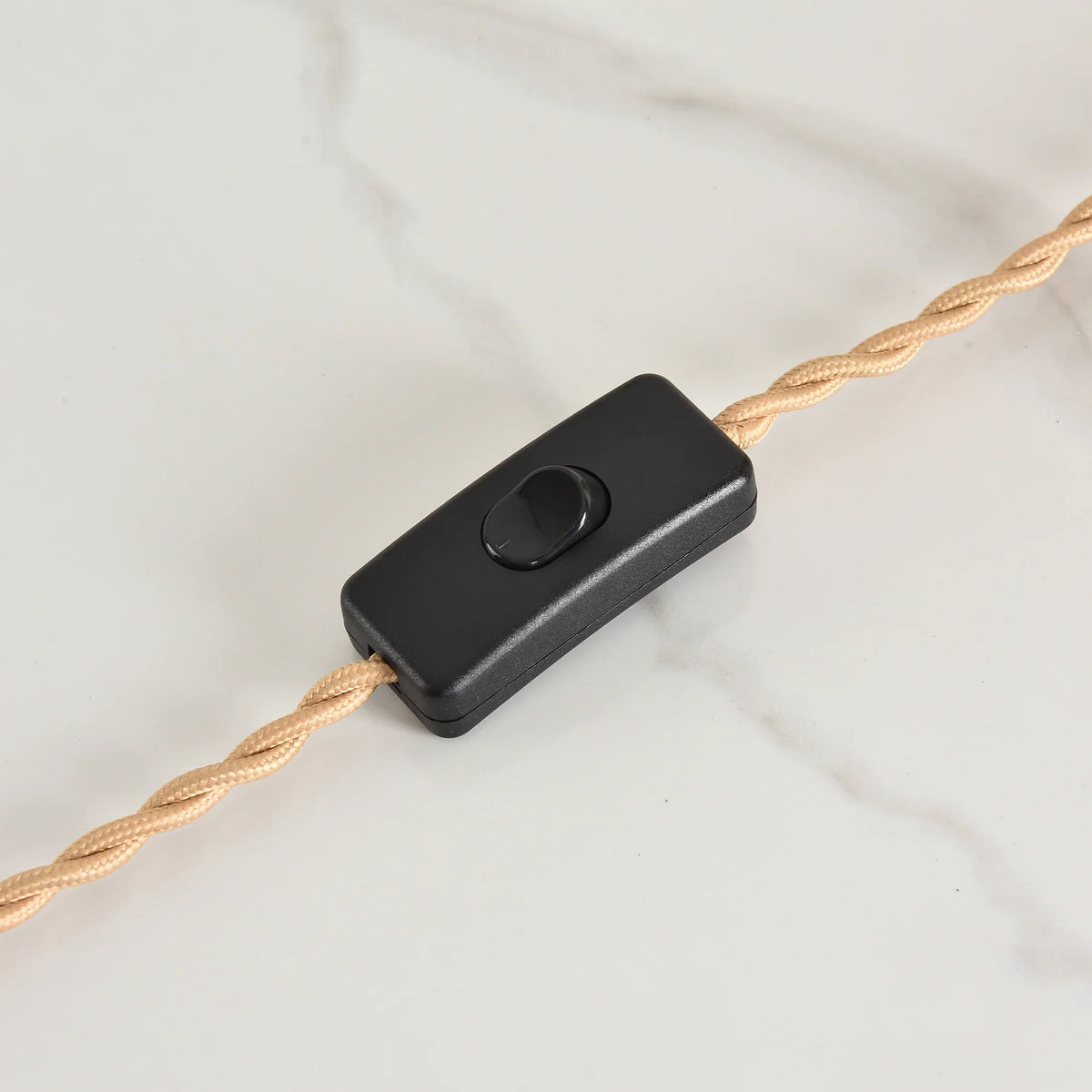 Black inline power switch on a twisted beige fabric electrical cord