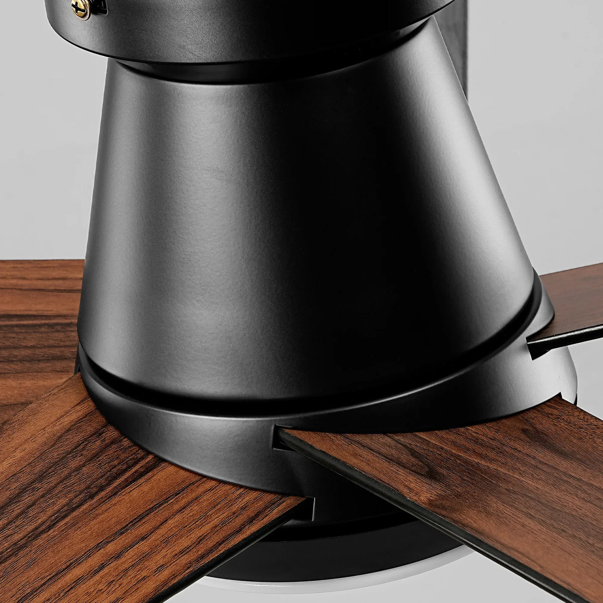 Close-up of a modern black ceiling fan with dark wood grain blades.